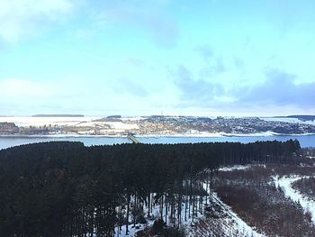 View of snow covered landscape against cloudy sky