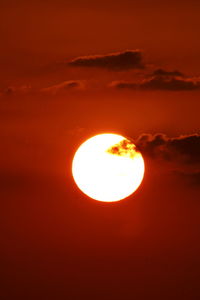 Low angle view of sun shining through clouds