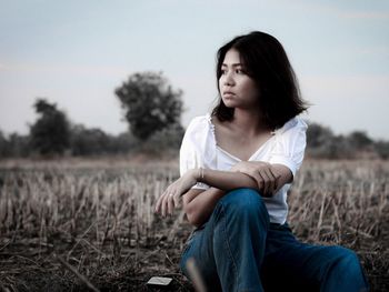 Young woman looking away on field