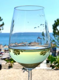 Close-up of beer glass against sky