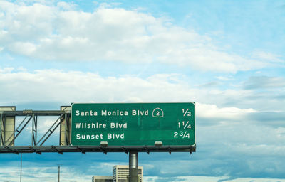 Low angle view of road sign against sky