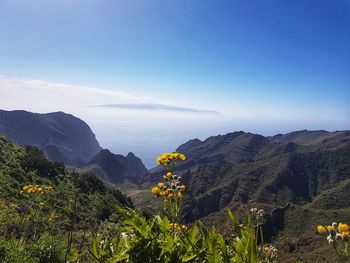 Scenic view of mountains against blue sky