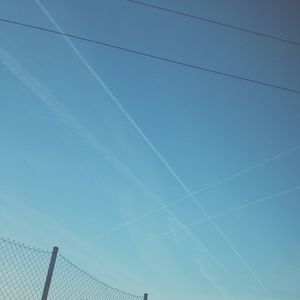 Low angle view of vapor trail against clear blue sky