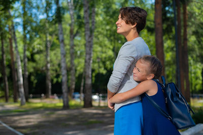 Father and son on tree against trees