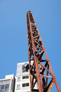 Low angle view of crane against clear blue sky