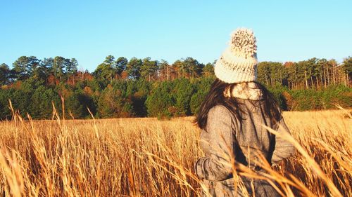 Woman standing on field against clear sky