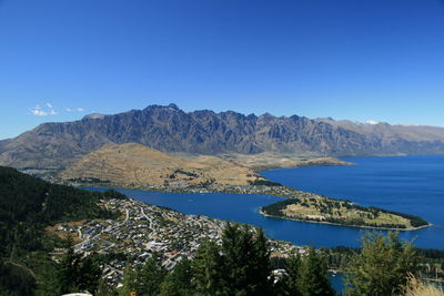 Scenic view of sea and town against clear sky