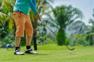 Low section of man standing on golf course