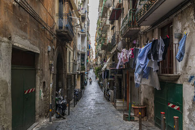 Clothes drying on footpath amidst buildings in naples, italy