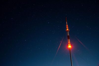 Low angle view of illuminated tower against stars in sky at night