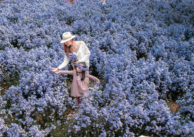 Full length of woman standing by flowering tree