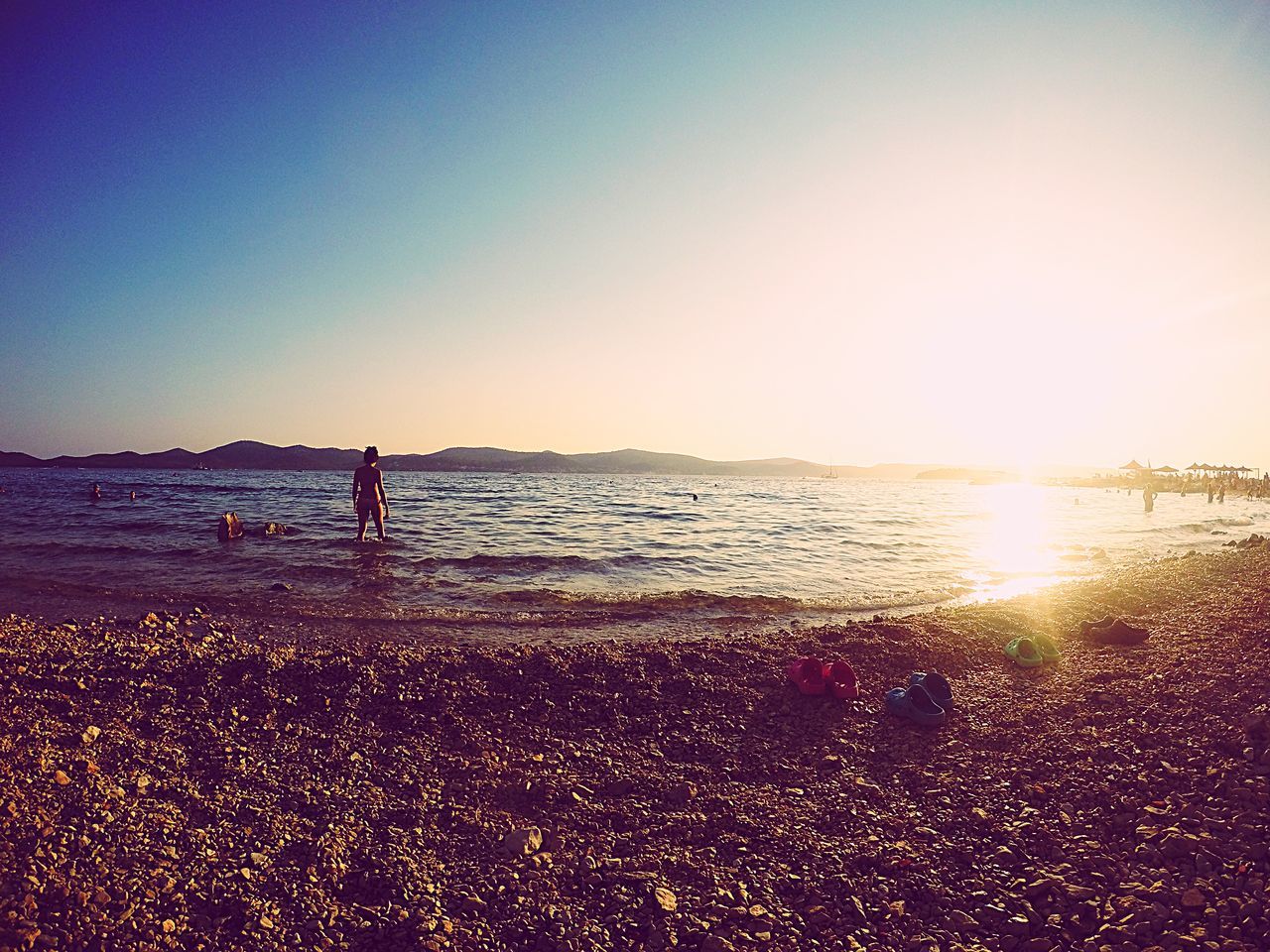 water, sea, beach, leisure activity, sunset, silhouette, horizon over water, lifestyles, clear sky, shore, scenics, copy space, tranquil scene, beauty in nature, men, tranquility, full length, vacations