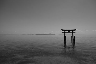 Japanese shrine on lake against clear sky