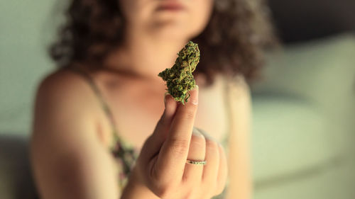 Midsection of woman holding marijuana