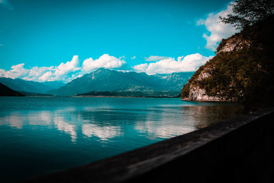 Scenic view of lake by mountains against sky