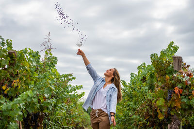 Woman standing by plants against sky