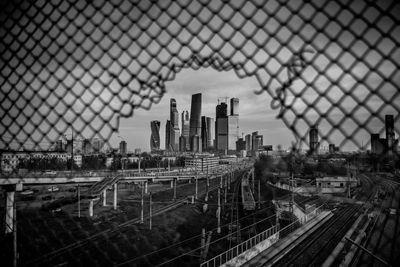 Aerial view of city buildings seen through chainlink fence