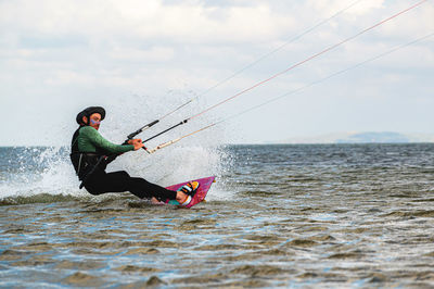 Man surfing in sea against sky