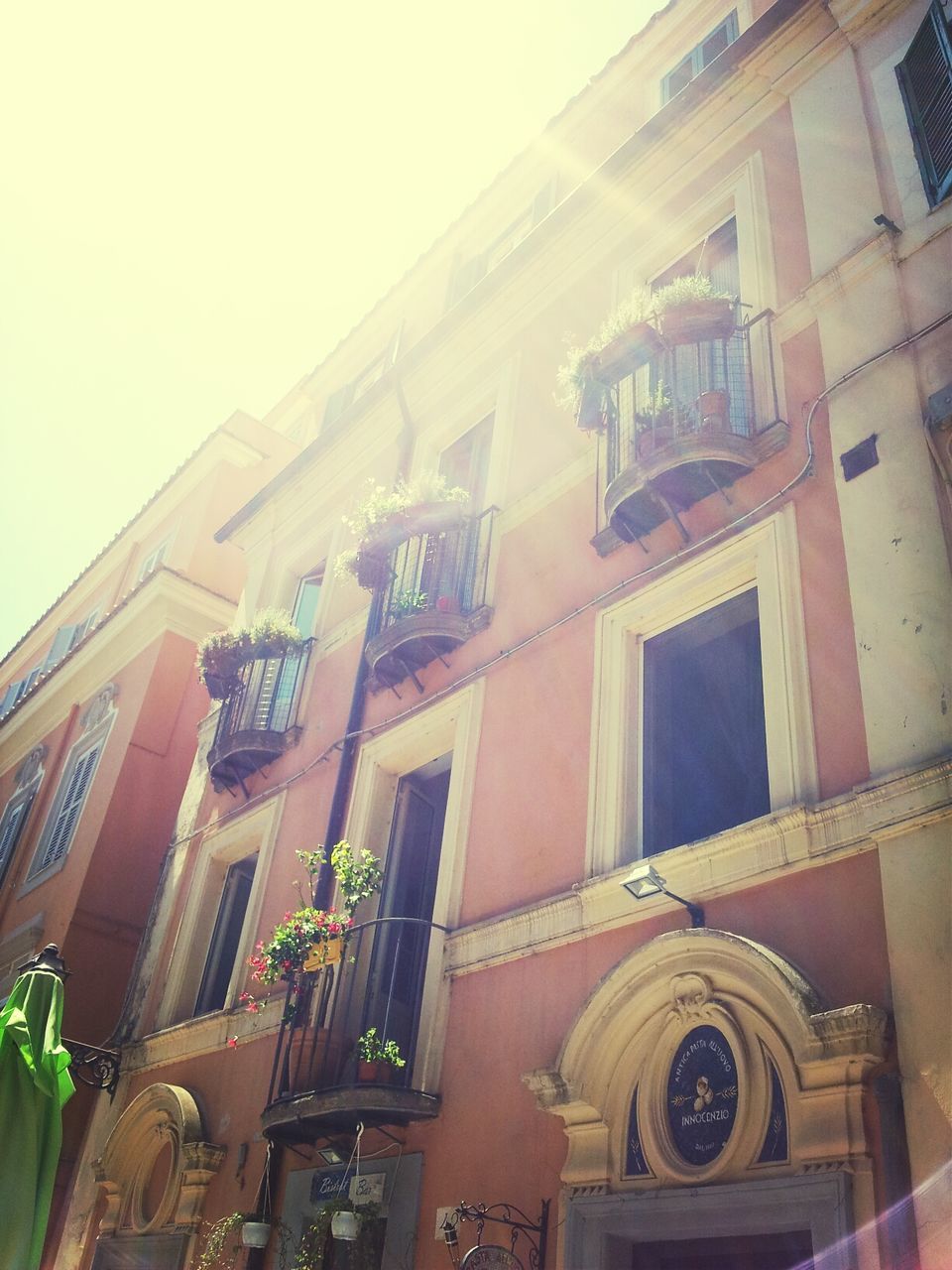 architecture, building exterior, built structure, low angle view, window, building, residential building, clear sky, residential structure, facade, day, city, outdoors, no people, sky, balcony, house, sunlight, old, history