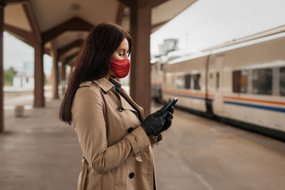 Woman standing by train at railroad station