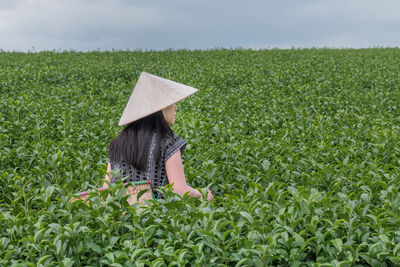 Rear view of woman working on field