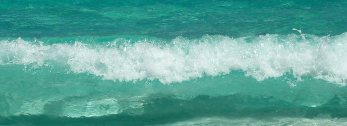 Close-up of waves breaking against sea
