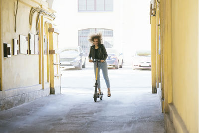 Teenage girl riding scooter in the city having fun