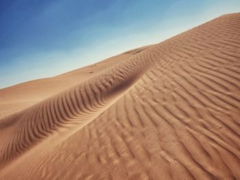 Sand dune in desert against sky