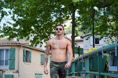 Shirtless tattooed young man walking in town