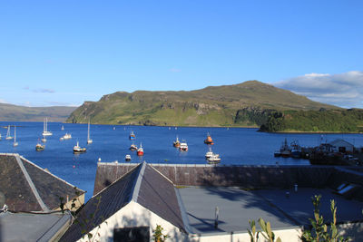 Boats sailing in sea against clear blue sky