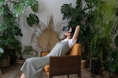Amazed young woman using vr in home garden, resting in relaxing virtual environment. cyberspace.