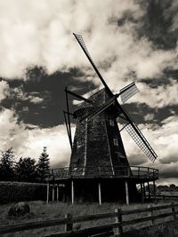 Low angle view of wind turbines in field