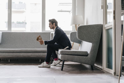 Architect on couch holding architectural model