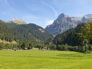 Scenic view of field and mountains against sky