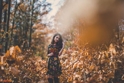 Woman standing on field in forest