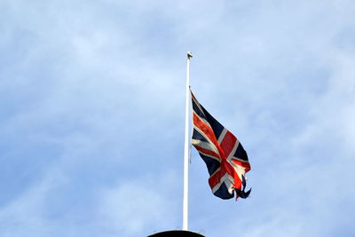 Low angle view of union jack flag against sky