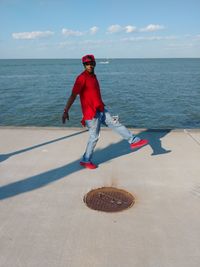 Full length of man standing on pier against sea