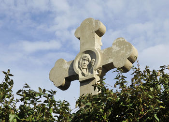 Low angle view of cross on tree against sky