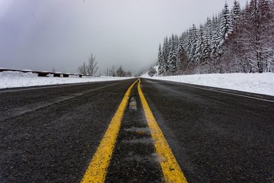 Surface level of road against sky during winter