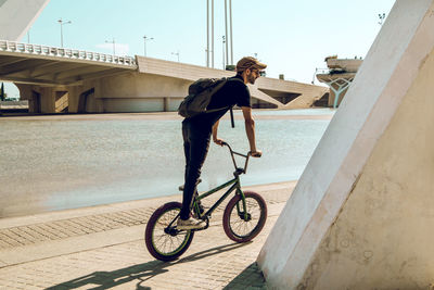 Side view of young man riding bicycle