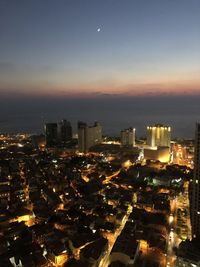 High angle view of illuminated buildings against sky at night