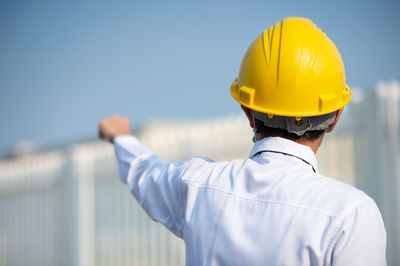 Rear view of man working against sky