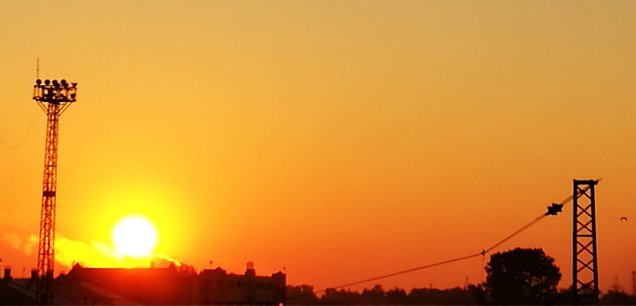 SILHOUETTE OF CITY AGAINST ORANGE SKY