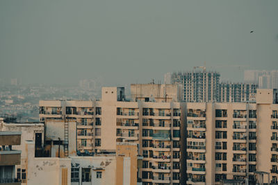 Buildings in city against clear sky