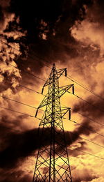 Low angle view of silhouette electricity pylon against sky