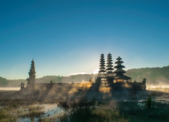 View of temple at lake tamblingan against clear sky