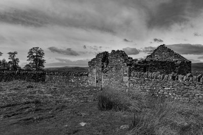 Old ruin on field against sky