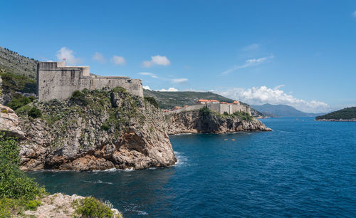 Scenic view of sea by buildings against sky