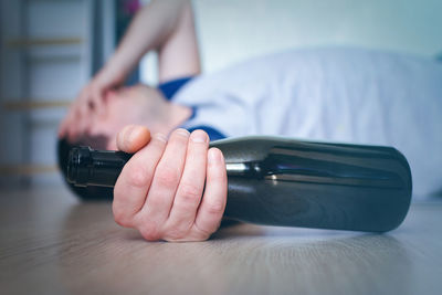 Midsection of person holding umbrella on table