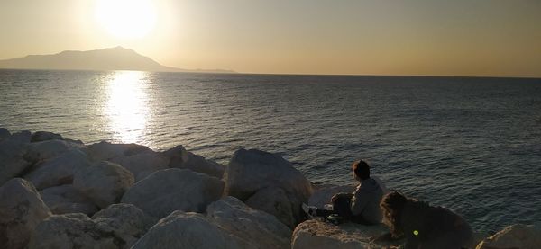 Scenic view of rocks in sea against sky during sunset